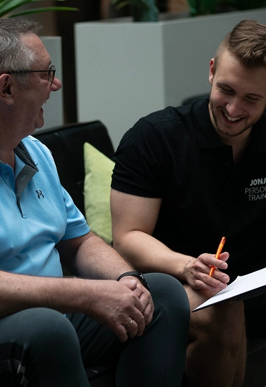 Ein Interessent im kostenlosen Erstgespräch mit seinem Fitness Trainer, in dem der Plan für das zukünftige Personal Coaching in Weiden besprochen wird.
